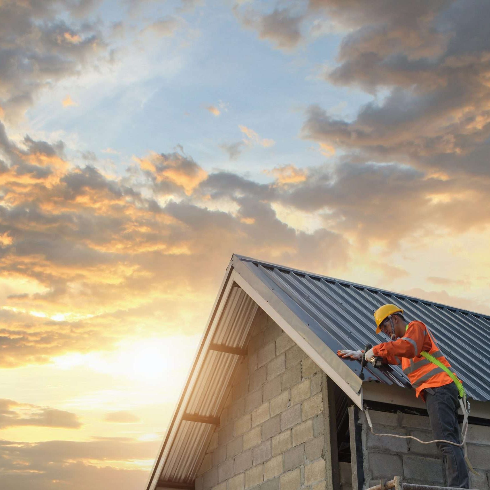 roofing at sunset with one builder working on it