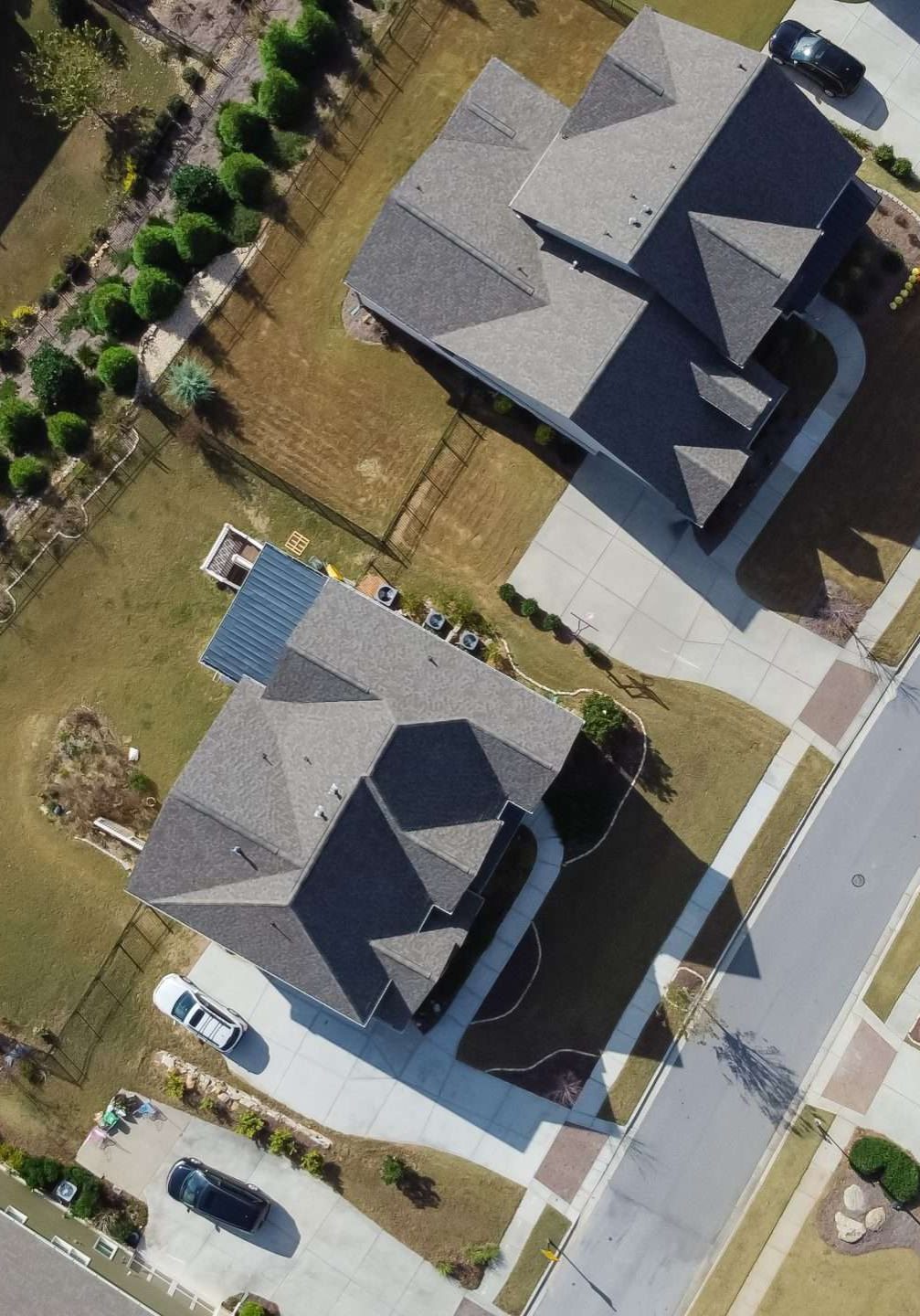 90 degree aerial view of brand new two story house with swimming pool and well trimmed yards, front garage in suburban residential neighborhood Flowery Branch, Georgia, US